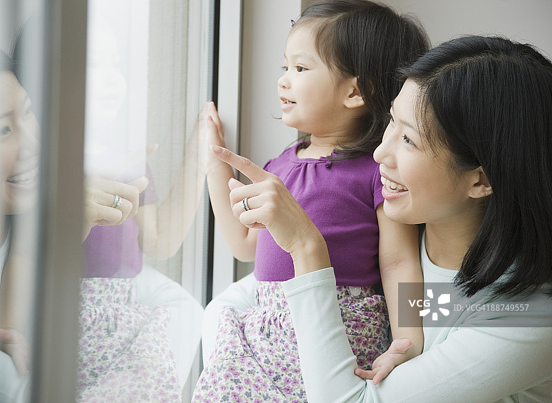 母亲和女儿望着窗外图片素材