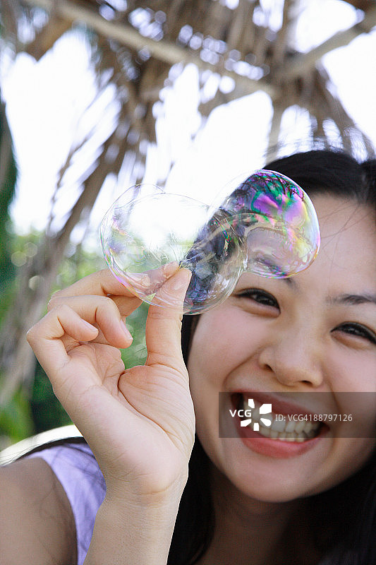 一个女人拿着一个心脏形状的泡泡的特写图片素材