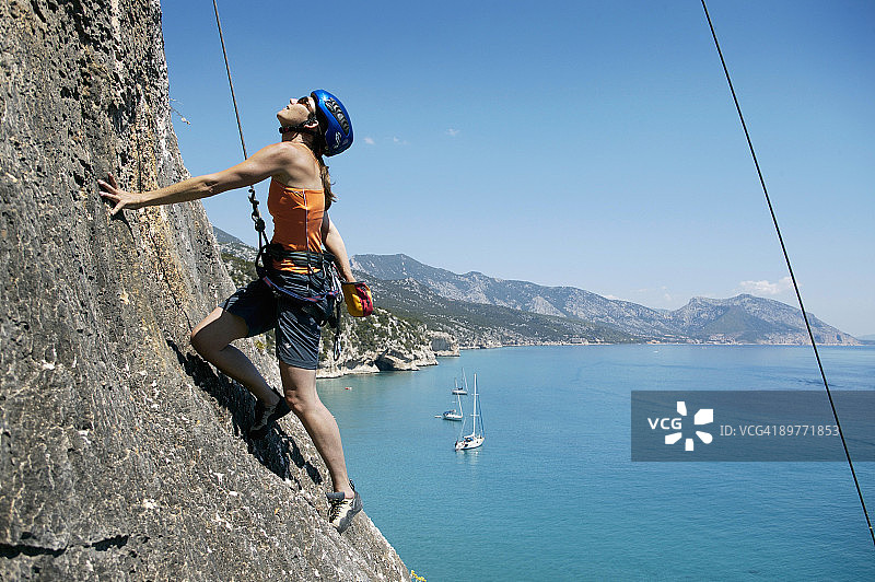 女子攀岩，背景是海湾图片素材