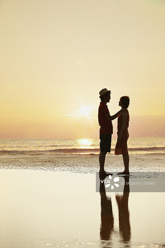 海滩上的年轻夫妇，剪影图片素材
