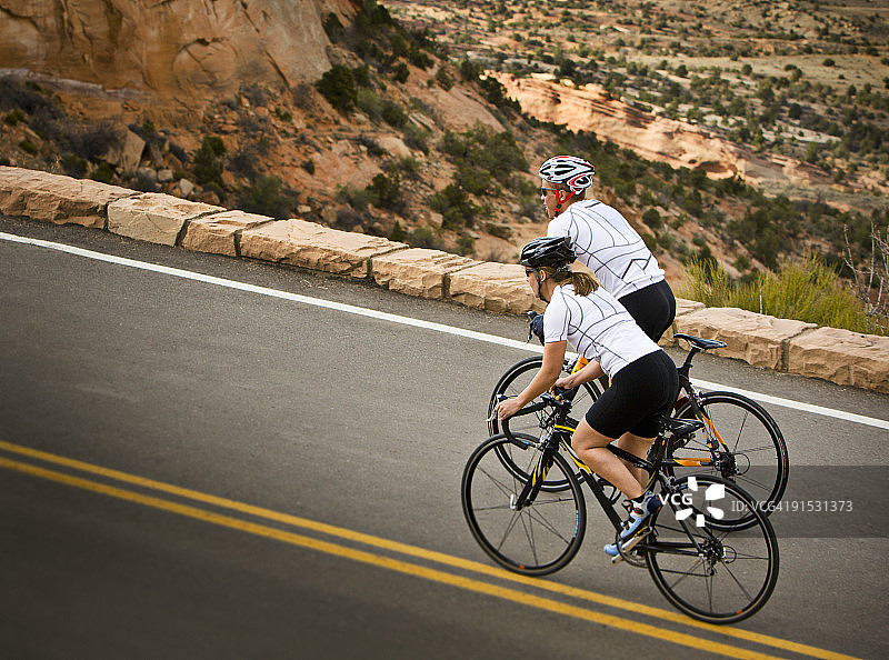 男性和女性骑自行车的侧视图。图片素材