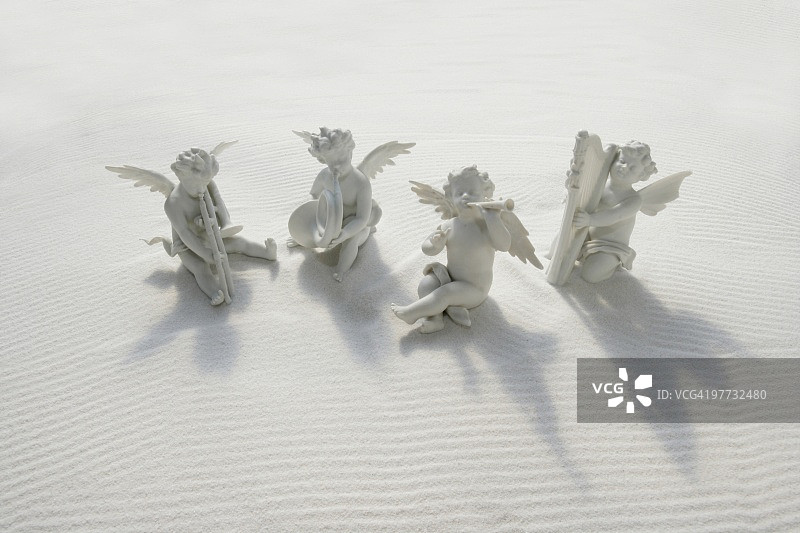 白沙上的天使雕像和乐器图片素材