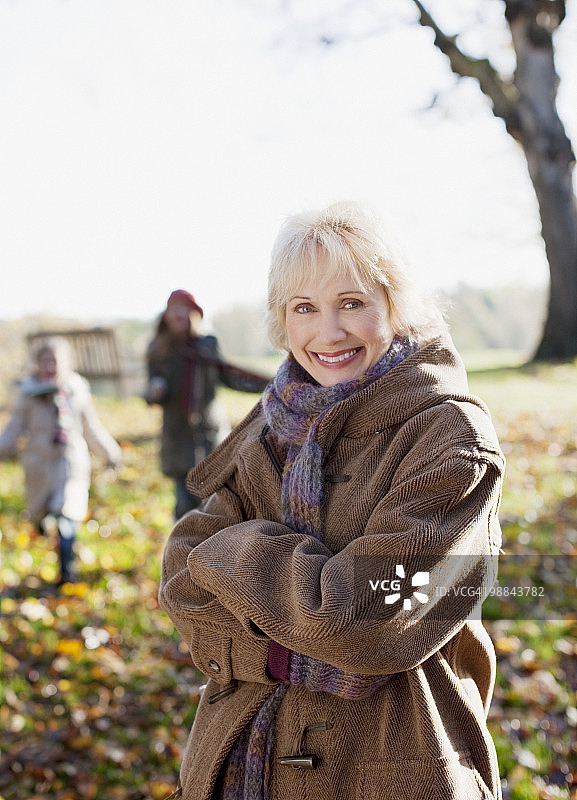 穿着大衣的微笑女人在户外的秋天图片素材