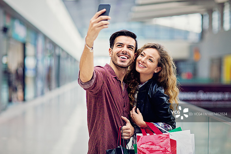 购物情侣在购物中心自拍/视频通话图片素材