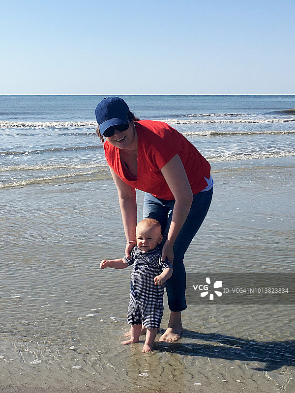 海滩上的千禧妈妈和男婴图片素材