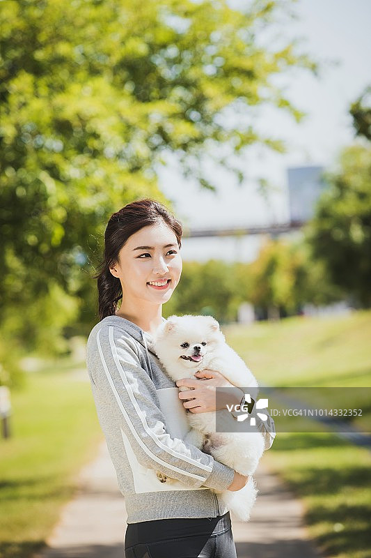 一个女人抱着一只可爱的狗图片素材
