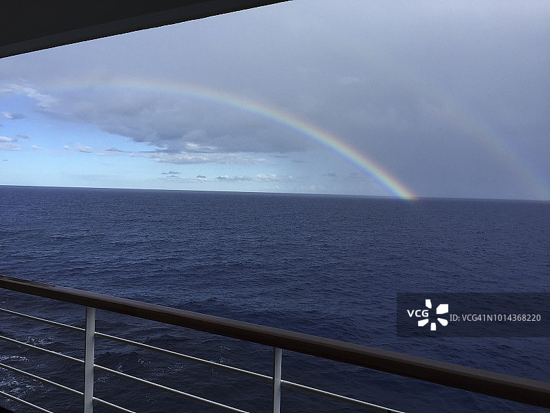 从游轮甲板上看彩虹，大海和戏剧性的天空图片素材