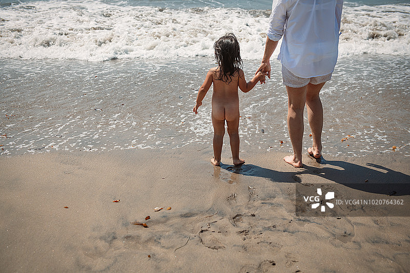 在海滩上和妈妈一起蹒跚学步图片素材