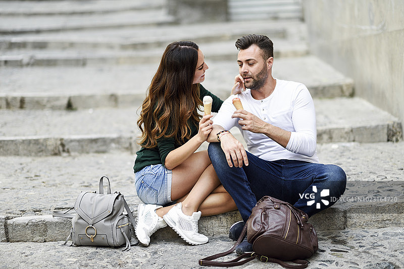 一对游客夫妇在城里吃甜筒冰淇淋图片素材