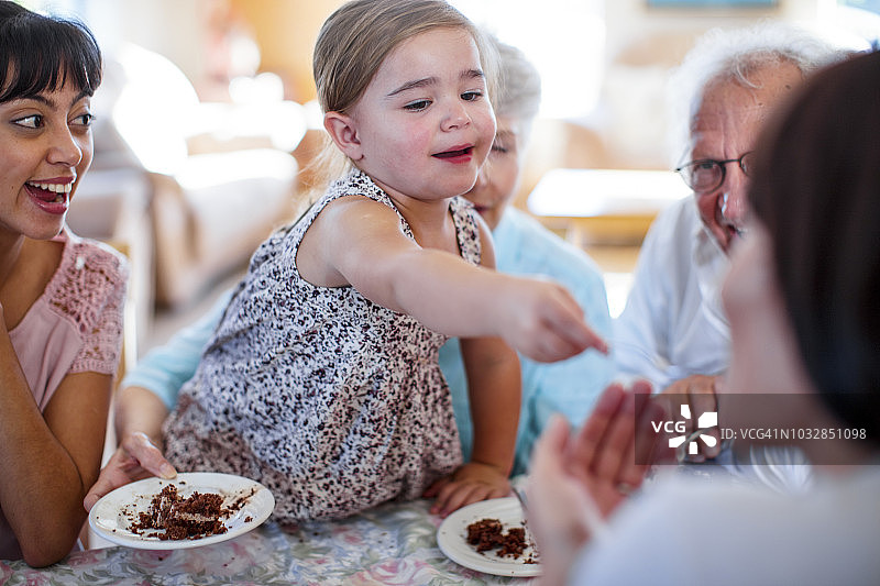 爷爷奶奶和孙女一起过生日，吃着巧克力蛋糕图片素材
