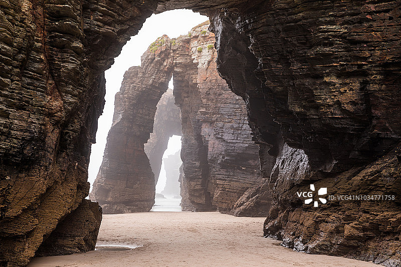 西班牙大教堂海滩上的天然岩石拱门图片素材