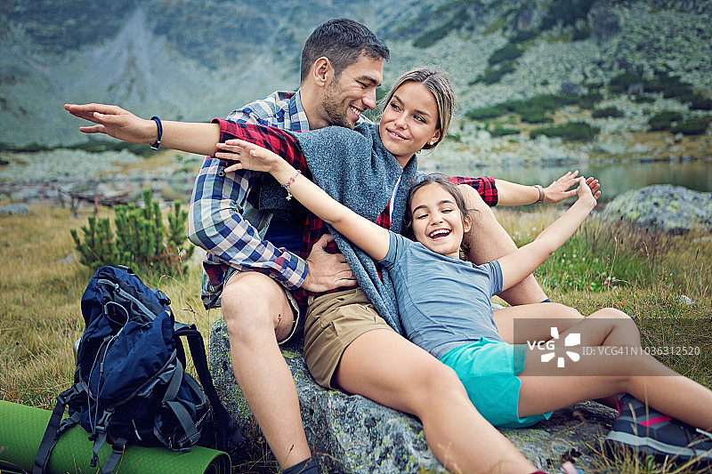快乐的徒步家庭在山上的湖边放松和享受大自然图片素材