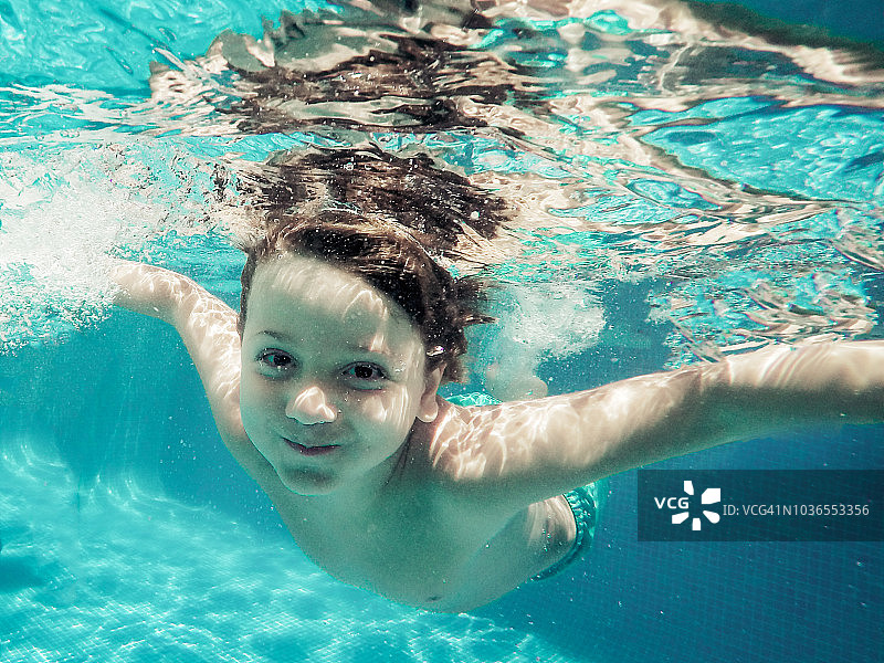 一个穿着蓝色泳衣的六岁男孩的水下视图图片素材