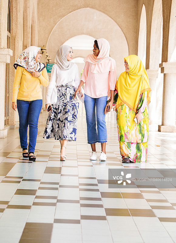 一小群穆斯林女大学生在校园里一起散步图片素材