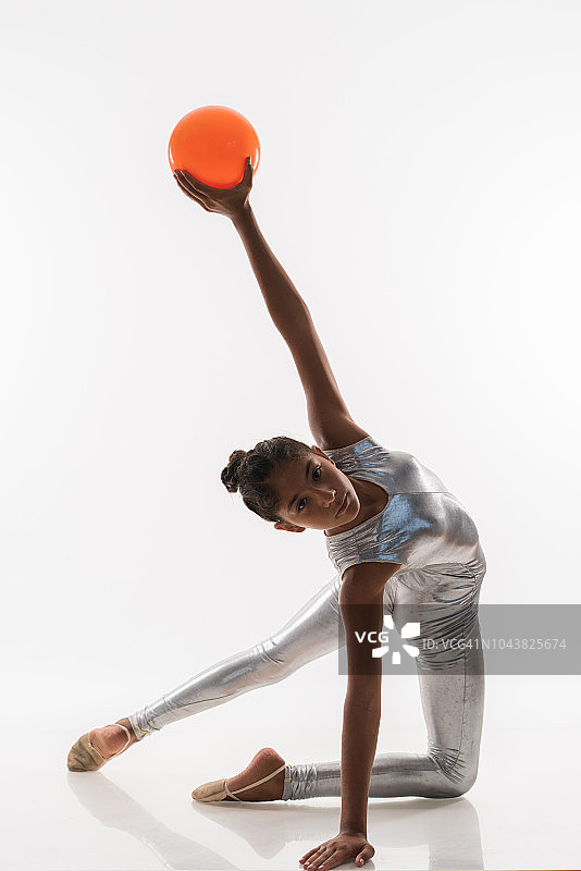 美丽的体操运动员十几岁的女孩做运动与球图片素材