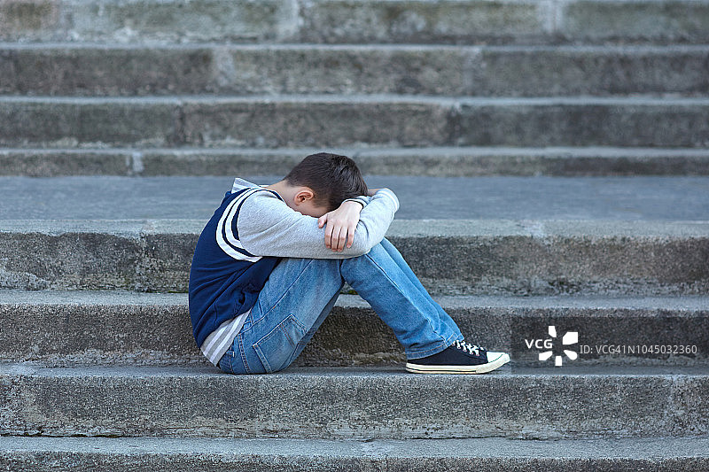 一个男生在学校的院子里哭图片素材