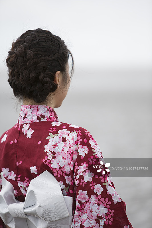 穿着日本和服的年轻女子在室外看着照相机图片素材