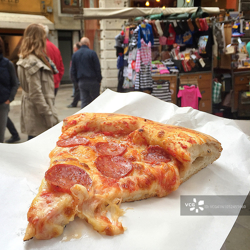 繁忙的威尼斯巷子里的一片意大利辣香肠披萨图片素材