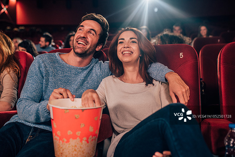 微笑的夫妇在电影院吃爆米花图片素材