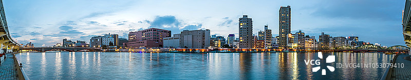 东京滨水天际线东京摩天大楼的全景照明，在sumida河，东京，日本晚上。图片素材
