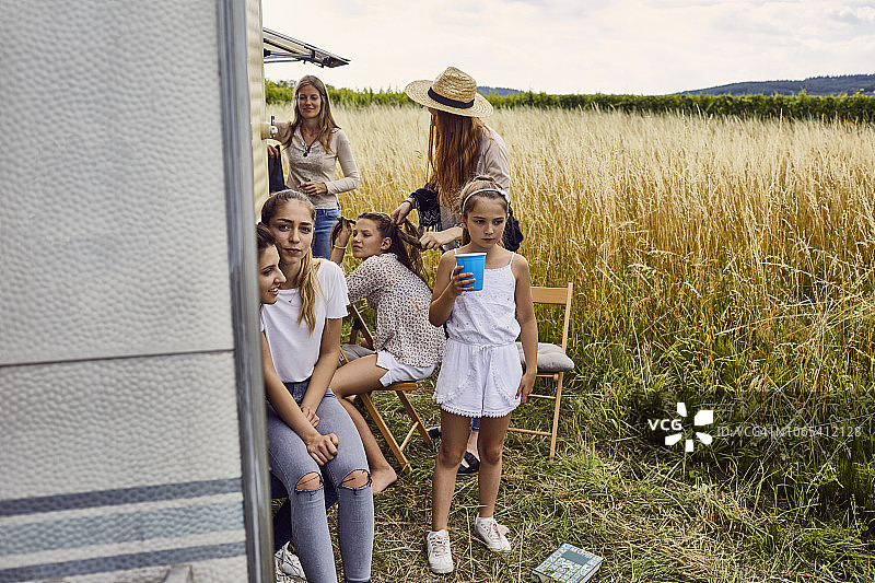 一群女性放松在一个大篷车附近的田野图片素材
