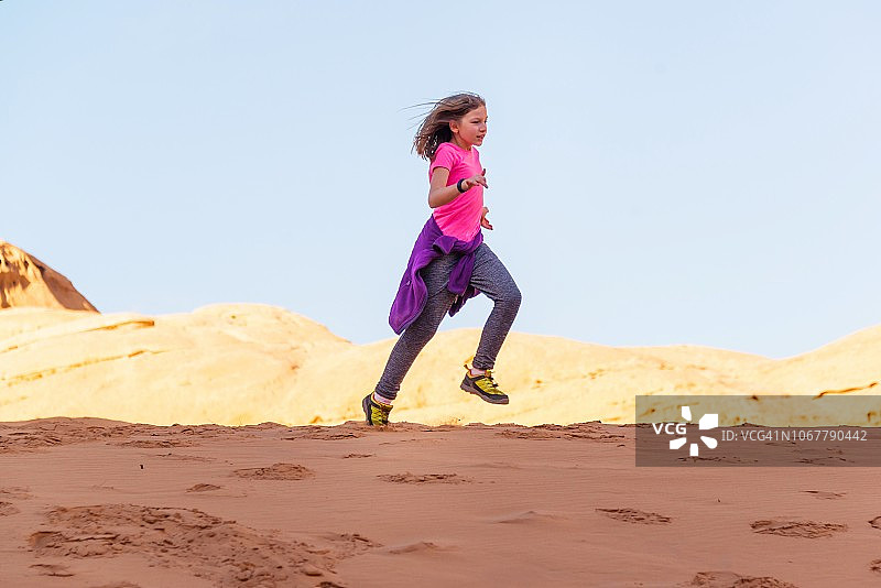 在约旦瓦迪拉姆沙漠奔跑的女孩图片素材