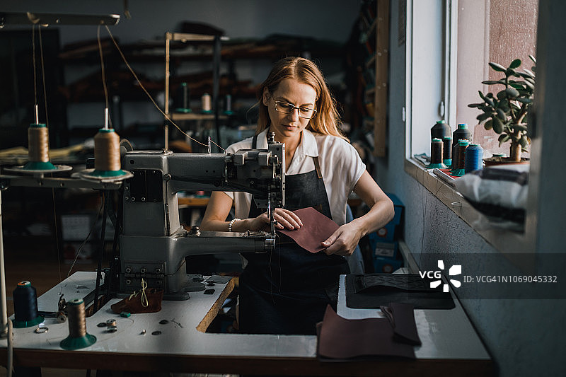 在纺织厂工作并使用缝纫机的妇女图片素材