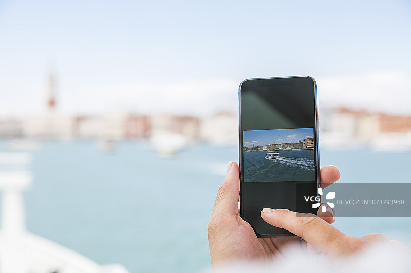 意大利威尼斯，游客用智能手机拍摄城市的特写图片素材