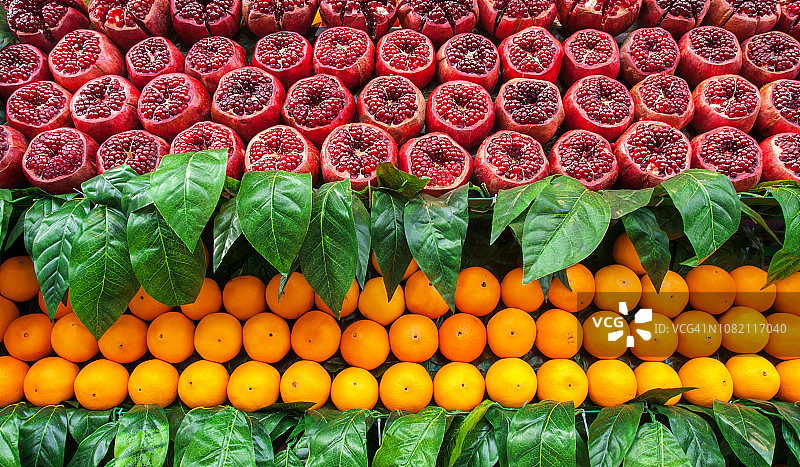 熟透的果汁，新鲜的石榴和橙子水果，切成两半，准备在街头和集市上的果汁图片素材