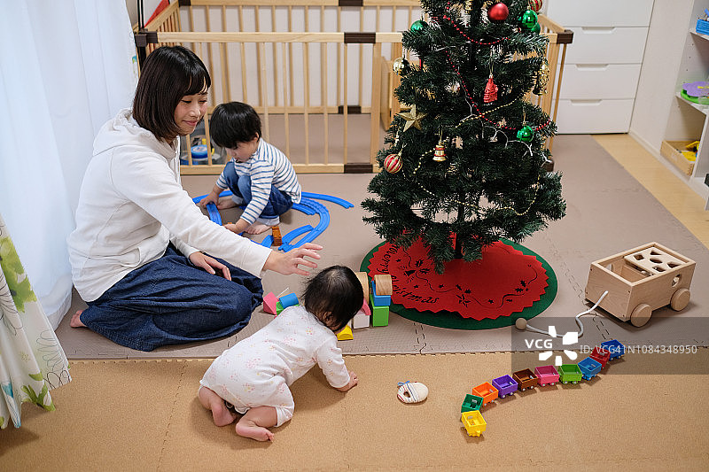 蹒跚学步的孩子，宝宝和妈妈在圣诞节一起玩玩具图片素材