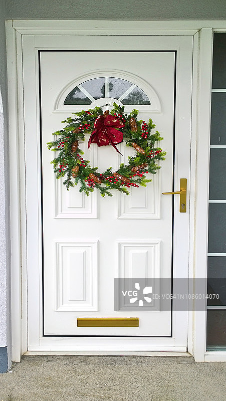 圣诞花环挂在白色的门上图片素材