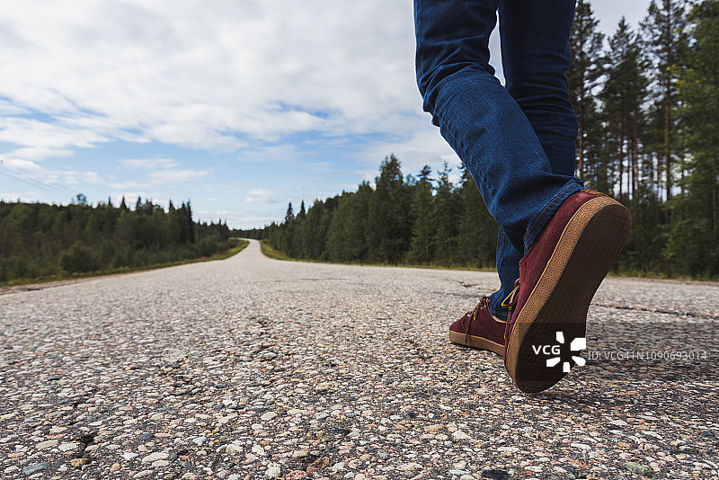 芬兰，拉普兰，人的脚走在空旷的乡间小路上图片素材