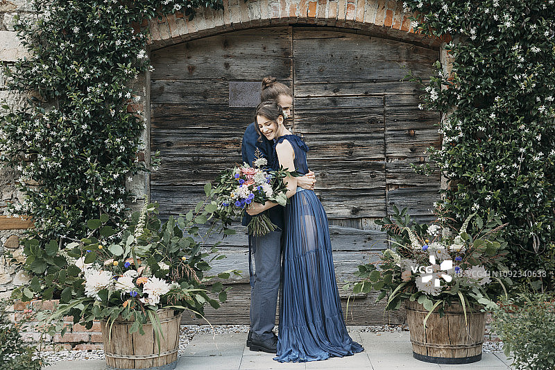 新娘和新郎站在木门前拥抱图片素材