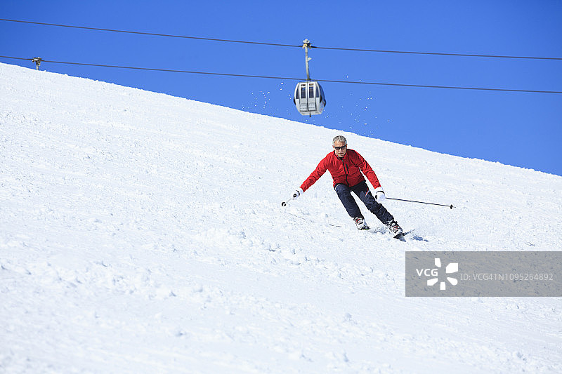 业余冬季运动高山滑雪。男子滑雪者在阳光明媚的滑雪场滑雪。高山雪景。Kronplatz，意大利南蒂罗尔的白云石山。图片素材