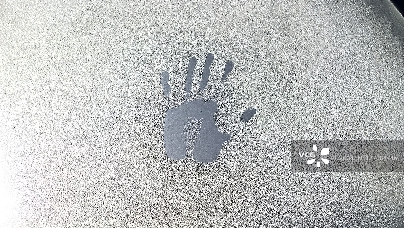 冰冻汽车挡风玻璃上的手印特写图片素材