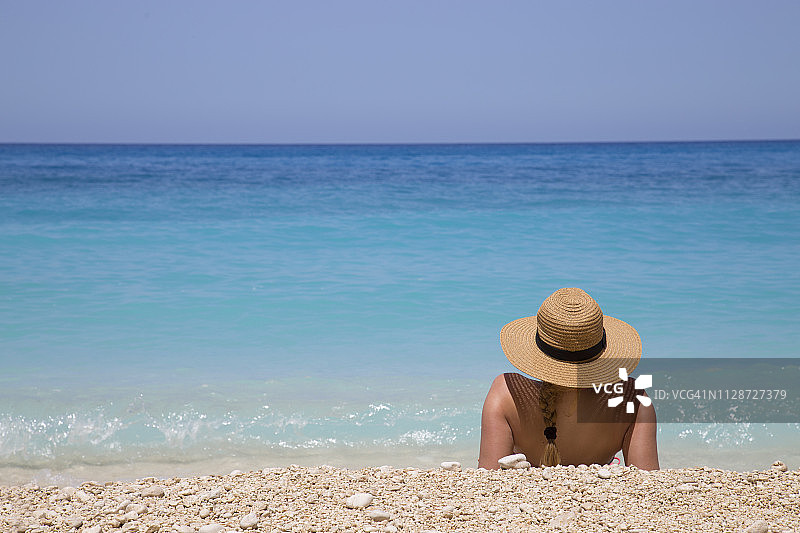 戴着夏天帽子的女人在海滩上图片素材