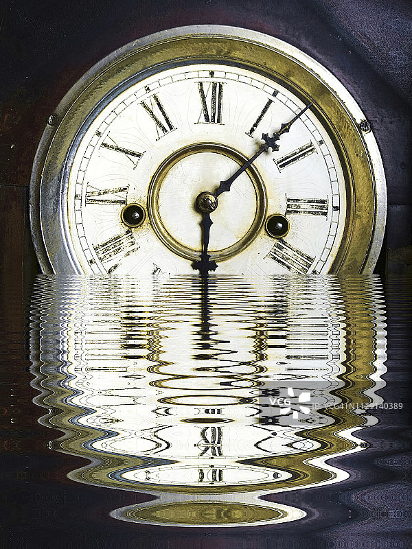 复古古董祖父时钟面与罗马数字数字和小时和秒针反映在涟漪水的扭曲。图片素材