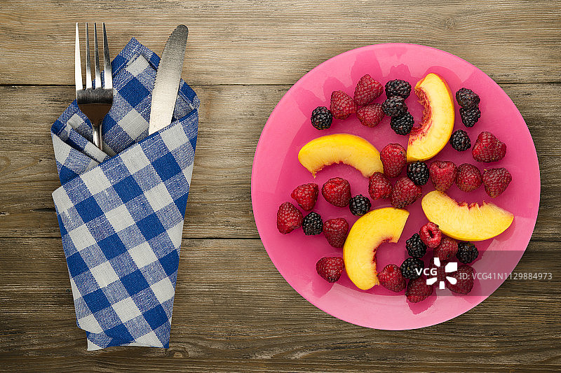 饮食,健康食品。黑莓、覆盆子、油桃一盘盘上。木制背景上的素食图片素材