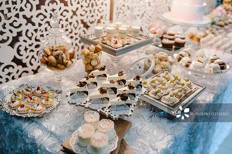桌子上有松饼，蛋糕，糖果，糖果，自助餐。甜点桌为一个聚会的好东西为婚礼宴会区。关闭了。糖果酒吧。装饰的很好吃。图片素材