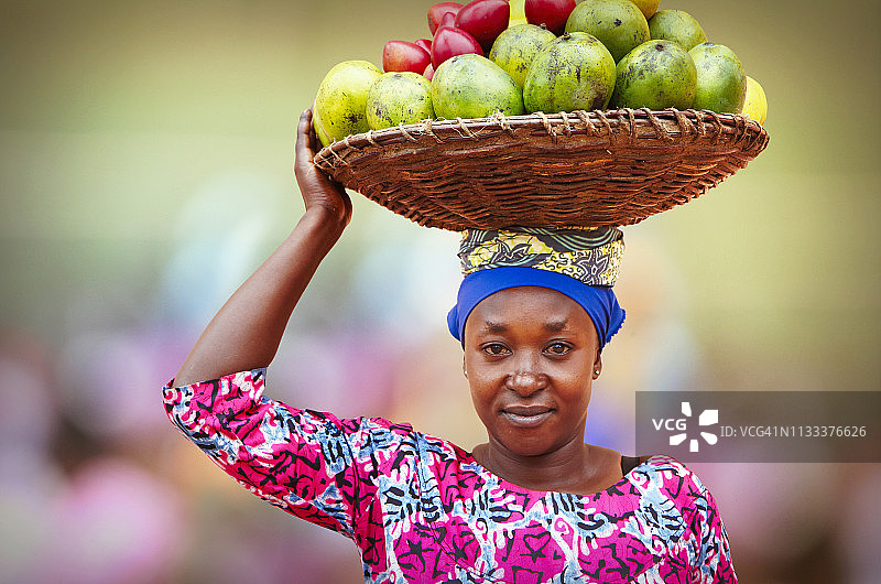 一名卢旺达妇女提着装满水果的篮子图片素材