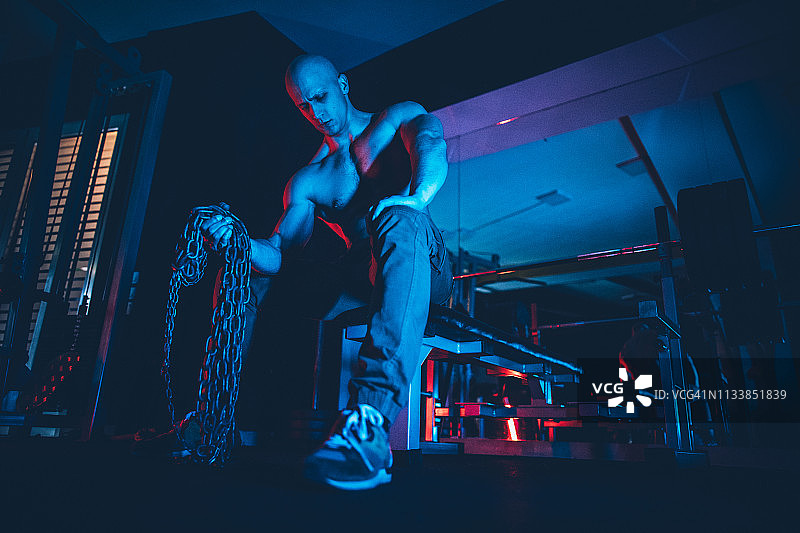肌肉男用铁链锻炼身体图片素材