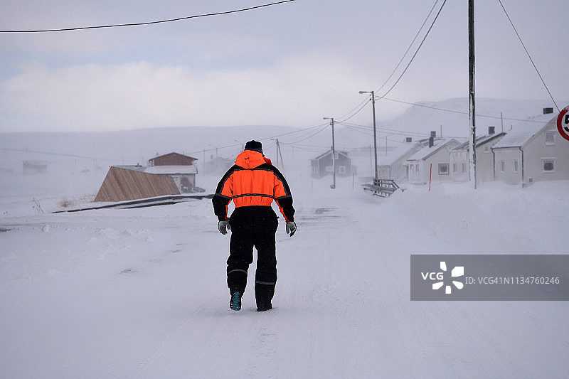 一位老人走在挪威北部基伯格结冰的路上图片素材