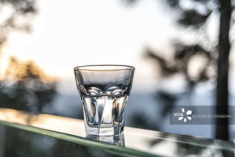 一杯水映衬着自然的落日风景图片素材