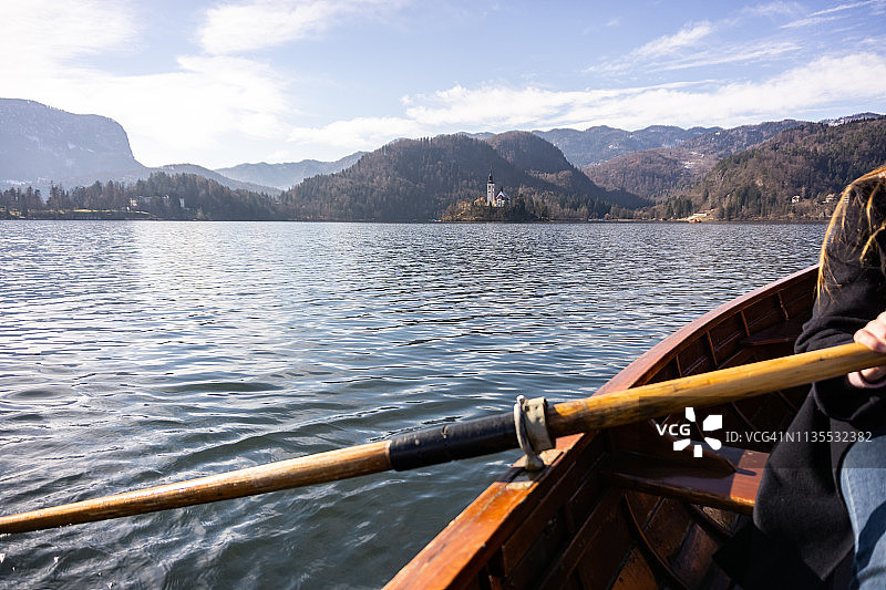 年轻女子用木船划桨-湖流血斯洛文尼亚木船划桨图片素材