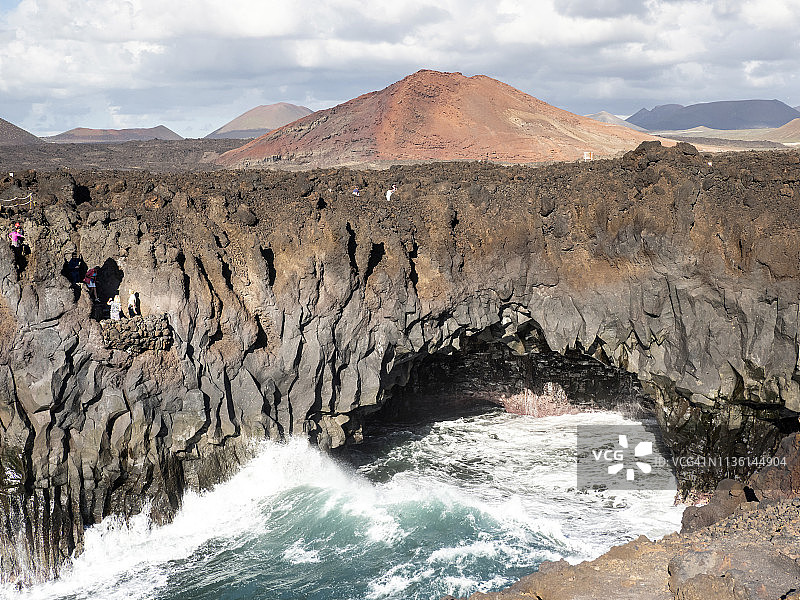 在西班牙加那利群岛的兰萨罗特岛，海浪对海岸的火山岩或悬崖的冲击。图片素材