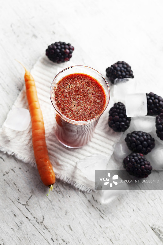 新鲜果汁饮料在玻璃，排毒，生莓和胡萝卜果汁冰沙，图片素材