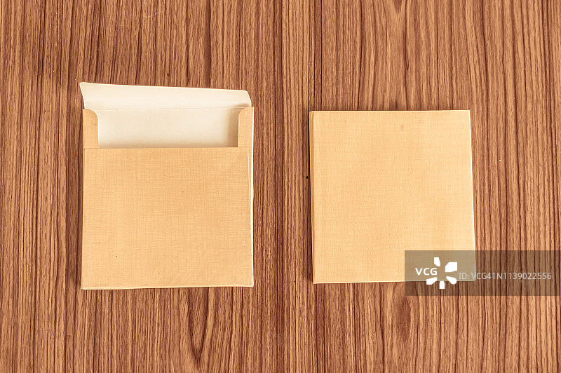 两套棕色信封正面和背面孤立在木桌硬木地板背景。名片空白。模型。顶部高角度视图对象与剪切路径。平的。文本复制空间图片素材