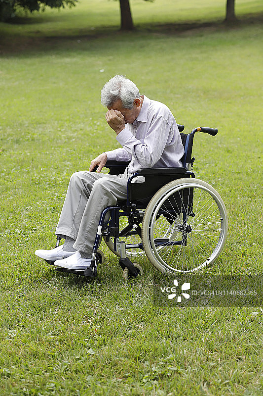 坐在轮椅上头痛的老人图片素材
