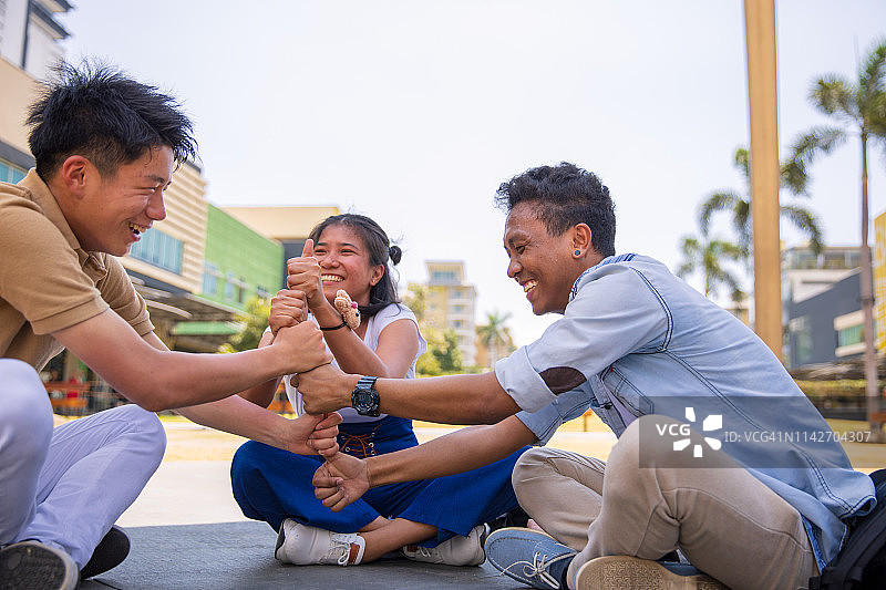 亚裔朋友在公园玩菲律宾本地游戏图片素材