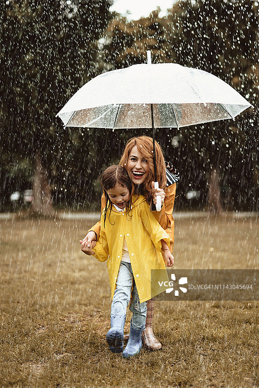 女人带着小女孩欣赏雨天图片素材